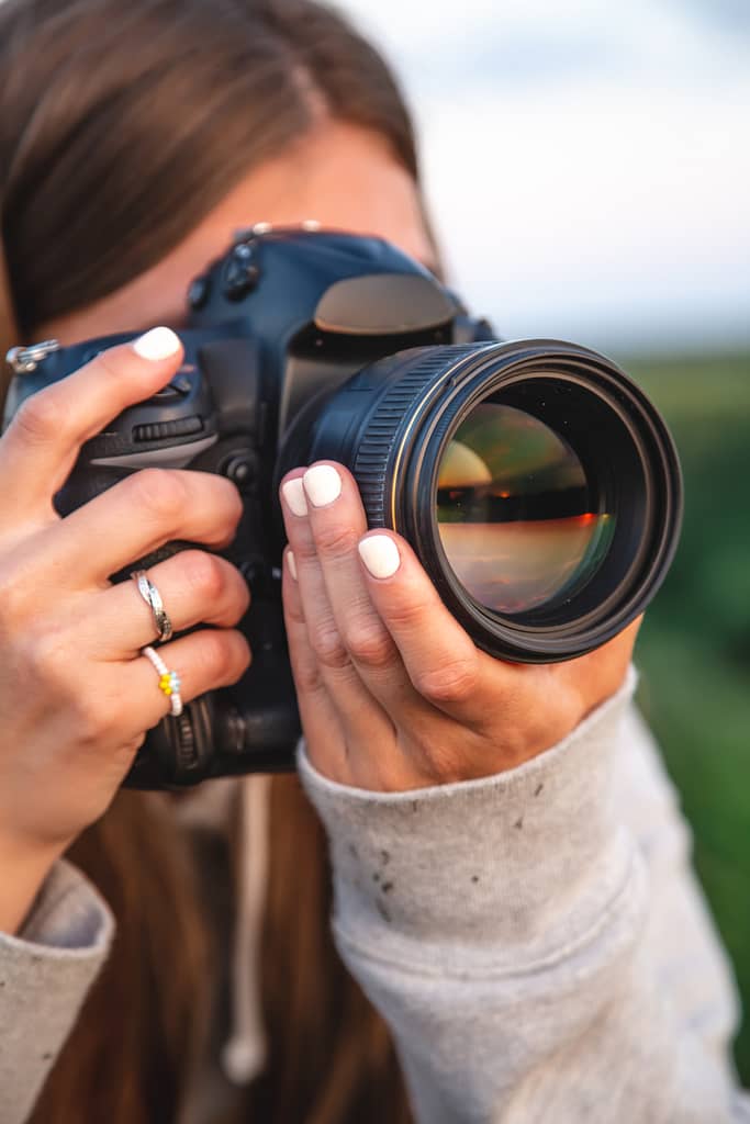 Fotografka z profesjonalnym aparatem robiąca zdjęcia podczas wycieczki po Nowym Jorku, uchwytując wyjątkowe chwile i miejskie krajobrazy, w ramach usług oferowanych przez Wycieczki Nowy Jork.